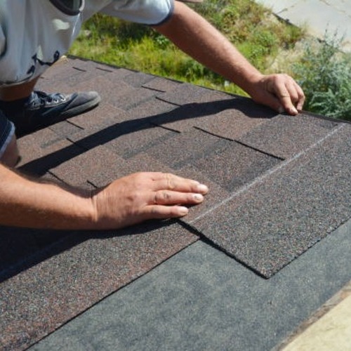 a worker replacing missing shingles