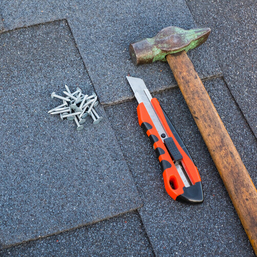 closeup of roofing tools on shingles